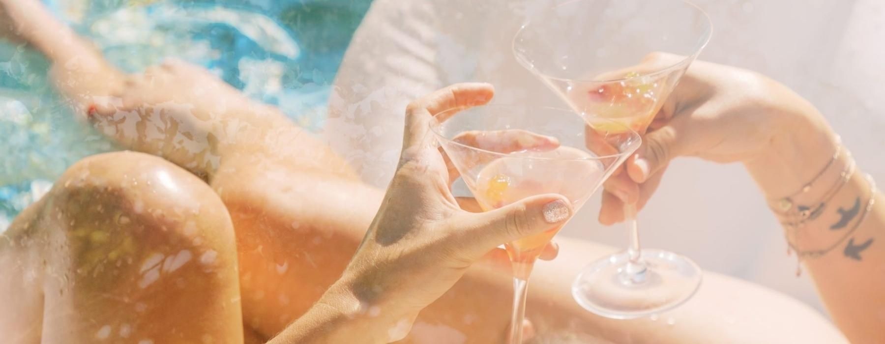 a couple of wine glasses on a beach