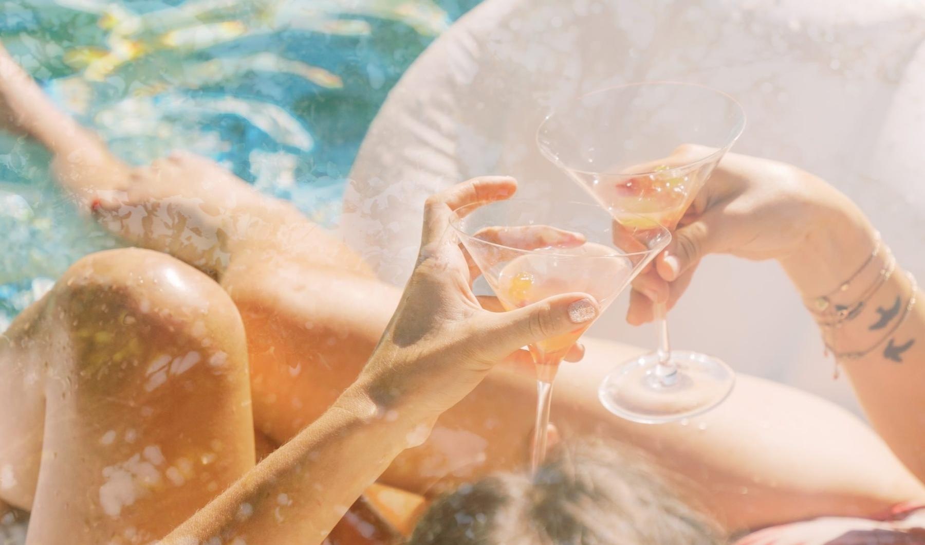 a couple of wine glasses on a beach